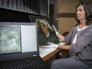 Senior Conservator Lesley Stevenson views Head of a Peasant Woman alongside an x-ray image of the hidden Van Gogh self-portrait. Photograph by Neil Hanna 