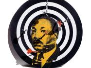 a dart board with martin luther king's portrait screenprinted on top in orange and black. 