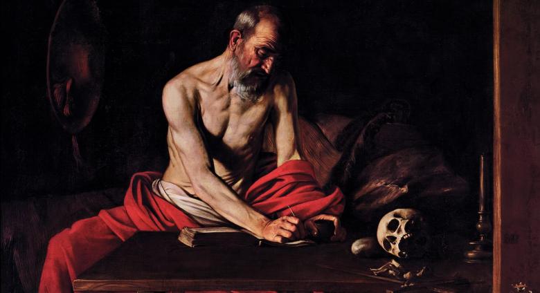 Muscular, shirtless Saint Jerome sits wrapped in red fabric, writing as though in transfixed state, atop a table that also bears a skull.