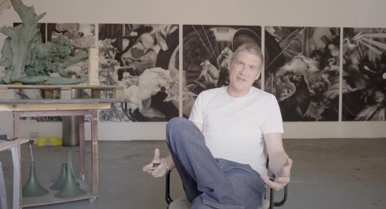 Hugo Wilson sitting in front of work in his UK studio