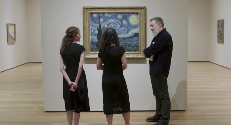 group looks at Starry Night on wall in gallery