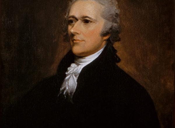 Alexander Hamilton Sits in a dark suit and looks off to the left. 