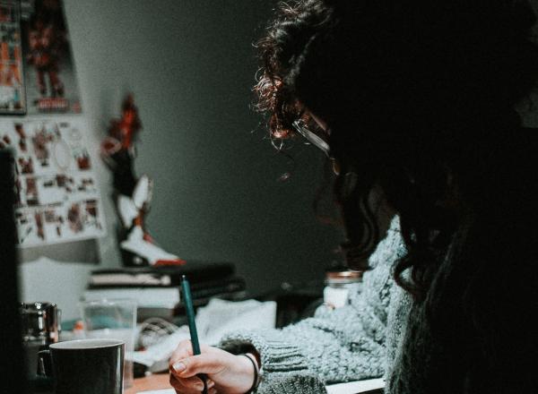 a person sits at a desk with a lamp