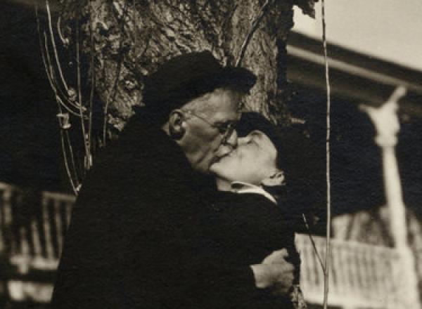 O'Keeffe and Stieglitz embracing under a tree  