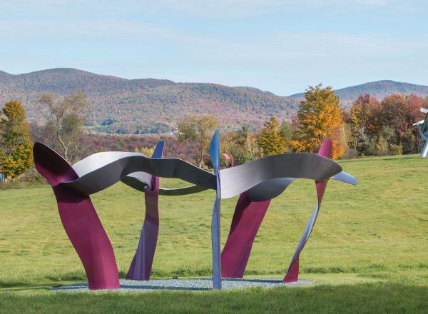 view of multiple sculptures in the park in front of a mountainous fall landscape. 