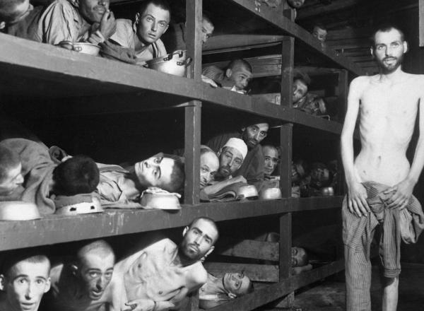 These are slave laborers in the Buchenwald concentration camp near Weimar; many had died from malnutrition when U.S. troops of the 80th Division entered the camp. The very ill man lying at the back on the lower bunk is Max Hamburger, who had TBC and severe malnutrition. He recovered and became a psychiatrist in the Netherlands. Second row, seventh from left is Elie Wiesel. Photograph taken 5 days after rescue.