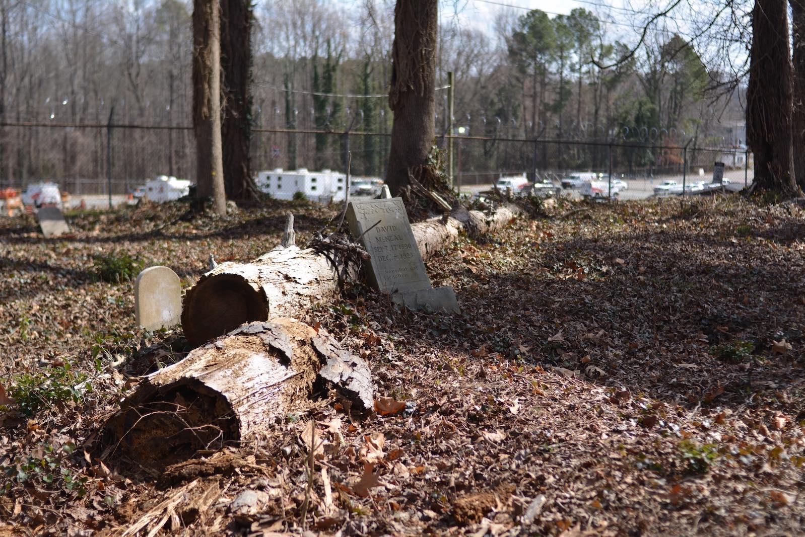 The backmost section of Geer cemetery is hedged in by a parking lot for a telephone company. Fallen trees are a common disruption in this portion of the cemetery and pose threats to the preservation of headstones.